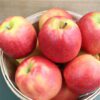 Basket of ripe red apples on table