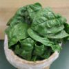 Bunch of fresh spinach in wooden basket