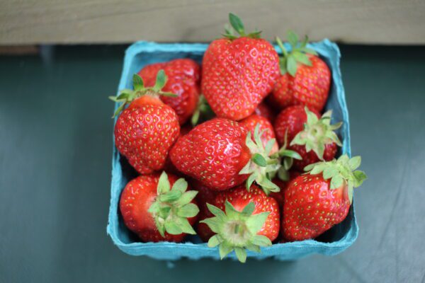 Blue carton of fresh ripe strawberries