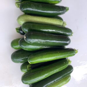 Fresh green zucchinis stacked on white background Fresh green zucchinis stacked on white background