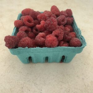Fresh raspberries in green berry carton