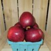 Shiny red apples stacked in blue carton