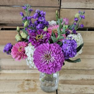 Purple and pink floral bouquet in glass jar
