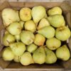 Wooden box overflowing with ripe green pears.