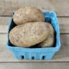 Basket containing several brown potatoes.