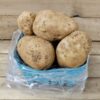 Basket of fresh, unwashed potatoes.