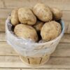 Basket filled with fresh, unpeeled potatoes.