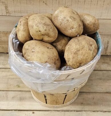 Basket filled with fresh, unpeeled potatoes.